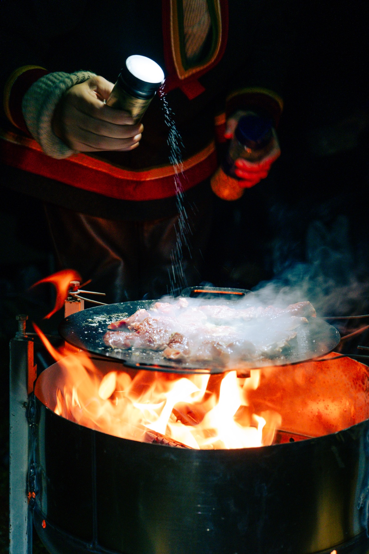 Steam rising from the pan over flames
